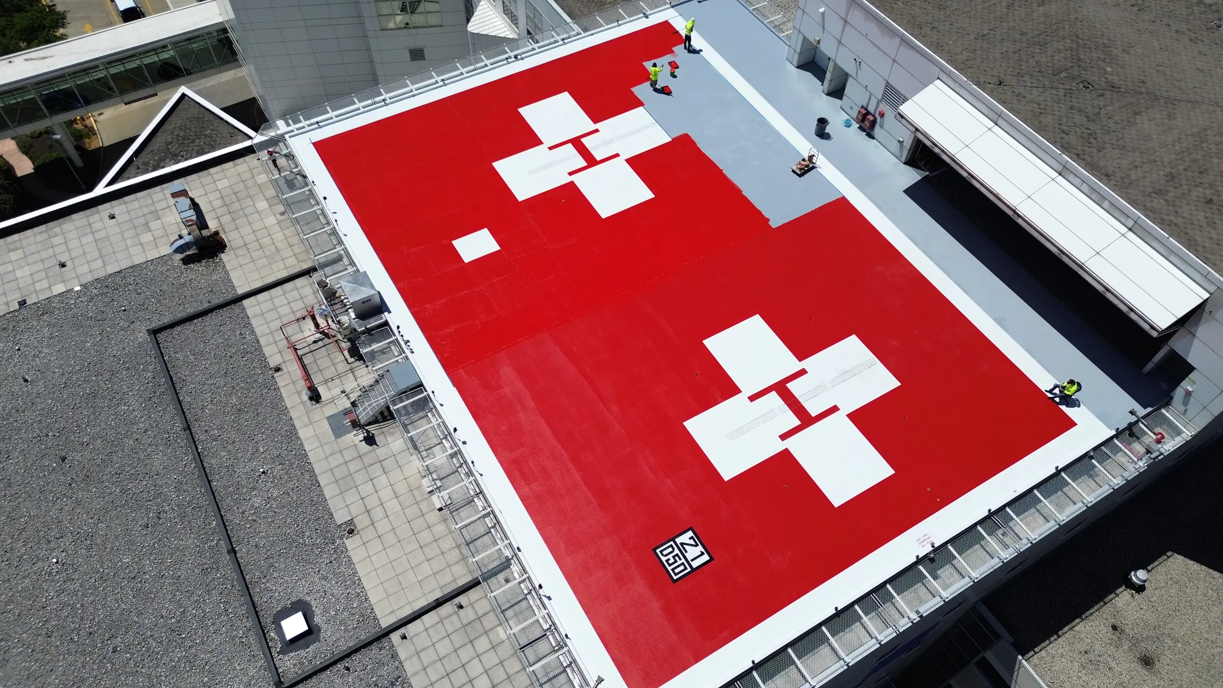 Two completed red rooftop helipads with white markings