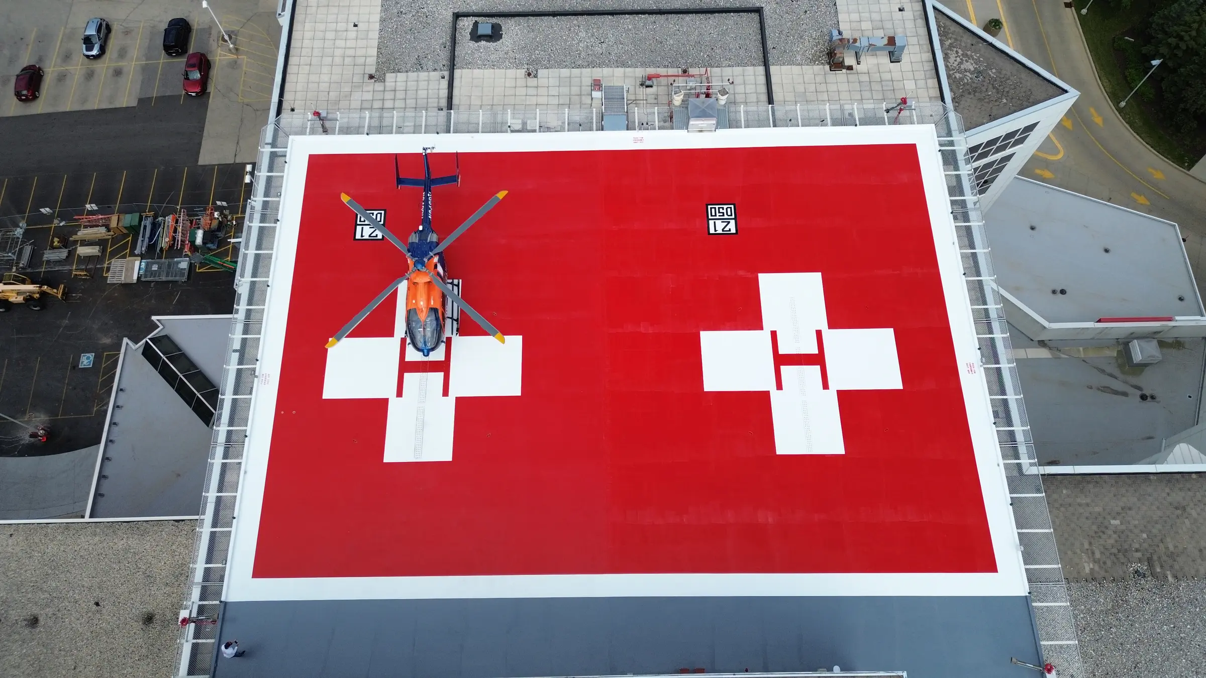 Helicopter on a completed red rooftop helipad